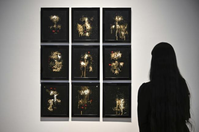 A person looks at AI artwork created by Pindar Van Arman's Emerging Faces at a preview for 'Augmented Intelligence' at Christie's on February 20, 2025 in New York City