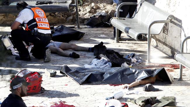 An Israeli medic inspects the body of a Palestinian at the scene of a shooting attack near the Damascus gate, Jerusalem's Old City, Wednesday, Feb. 3, 2016. Three Palestinians carrying automatic weapons, explosive devices and knives shot and stabbed two Israeli security officers in Jerusalem on Wednesday, wounding both before police shot and killed the attackers, police said. (AP Photo/Mahmoud Illean)