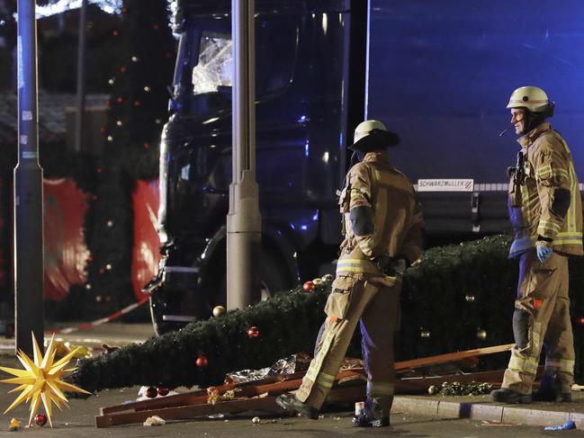 Firefighters look at a toppled Christmas tree after a truck ran into a crowded Christmas market and killed several people in Berlin, Germany on December 19, 2016. Picture: AP