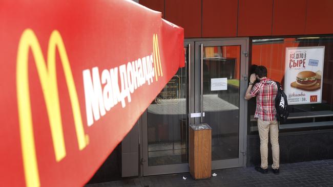 A man looks through the window at the entrance of a closed branch of McDonald's in Moscow.