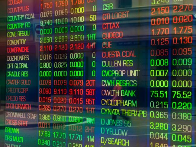 Sydney, Australia - March 5, 2014: An office worker crossing a road is reflected in the glass display of a trading screen at the Australian Stock Exchange on Bridge Street.