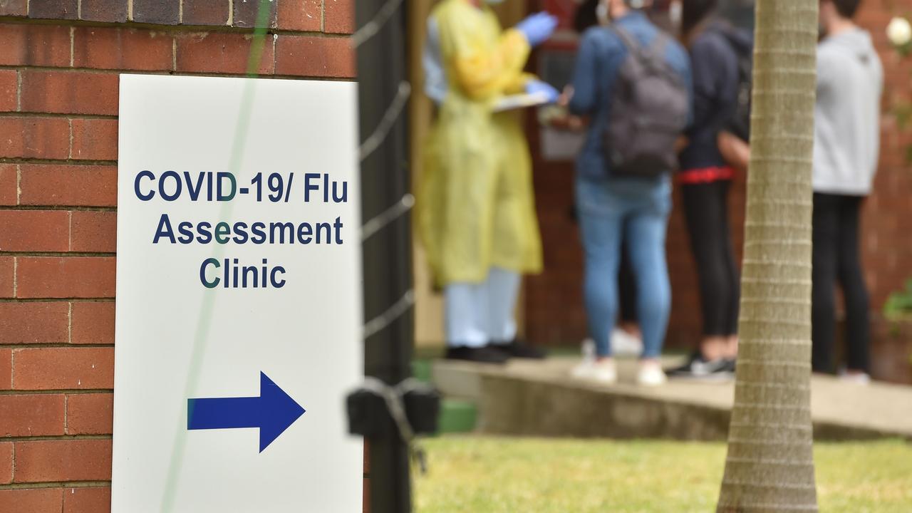 A health worker talks to visitors at a Covid-19 testing centre in Sydney on March 23, 2020. - With the imminent closure of pubs, restaurants, cafes and entertainment venues in Sydney, large queues formed outside Australian unemployment benefit offices as online services crashed as the prime minister warned the coronavirus pandemic would cause an economic crisis akin to the Great Depression. (Photo by PETER PARKS / AFP)