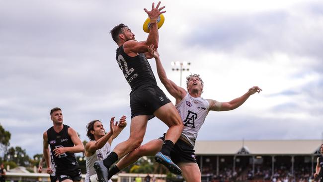 Charlie Dixon flies for a mark over Trent McKenzie on Friday night. Picture: Matt Turner/AFL Photos via Getty Images