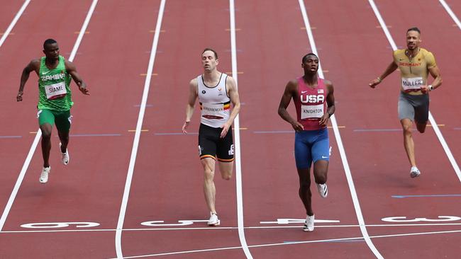 USA's Erriyon Knighton (2R) crosses the finish line to win ahead of third-placed Belgium's Robin Vanderbemden (2L), Zambia's Sydney Siame  (L) and Germany's Steven Muller (R) in  the men's 200m heats during the Tokyo 2020 Olympic Games at the Olympic Stadium in Tokyo on August 3, 2021. (Photo by Giuseppe CACACE / AFP)