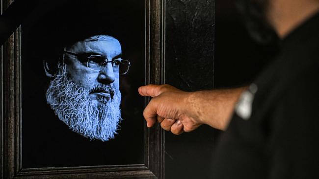 A man points to a television set displaying an image of the late Hezbollah leader Hassan Nasrallah during a broadcast. Picture: AFP