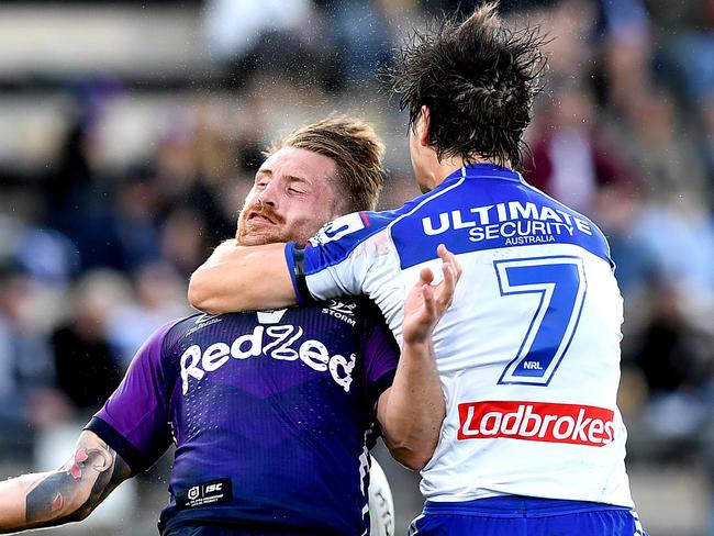 SUNSHINE COAST, AUSTRALIA - AUGUST 08: Cameron Munster of the Storm is hit high in the tackle by Lachlan Lewis of the Bulldogs during the round 13 NRL match between the Melbourne Storm and the Canterbury Bulldogs at Sunshine Coast Stadium on August 08, 2020 in Sunshine Coast, Australia. (Photo by Bradley Kanaris/Getty Images)