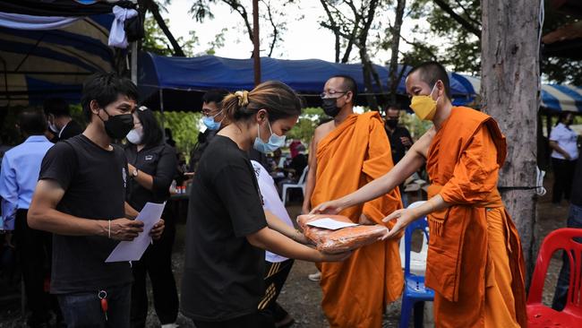 Members of the community make donations to the victims' families as rites begin at the Wat Rak Samakee temple. Picture: Getty