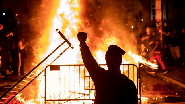 A protester raises a fist near a fire during a demonstration outside the White House over the death of George Floyd. Picture: AFP