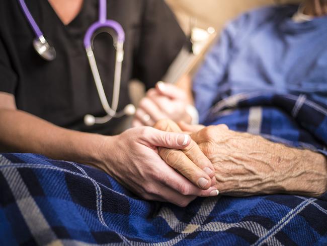 A stock photo of a Hospice Nurse visiting an Elderly male patient who is receiving hospice/palliative care.