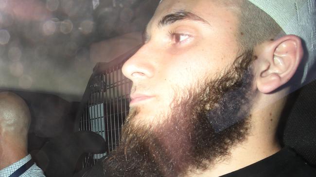 A picture of Agim Kruezi as he was  taken to Brisbane Watchhouse after he was arrested in terror-related raids south of Brisbane.