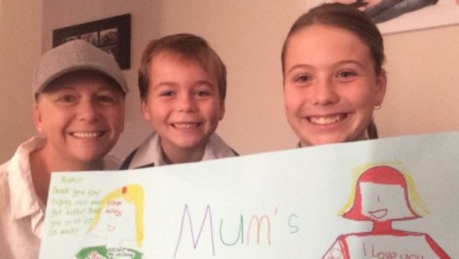 Tracey Lewis with her two children and a handmade card that reads: Mum’s last chemo! (Pic: supplied)