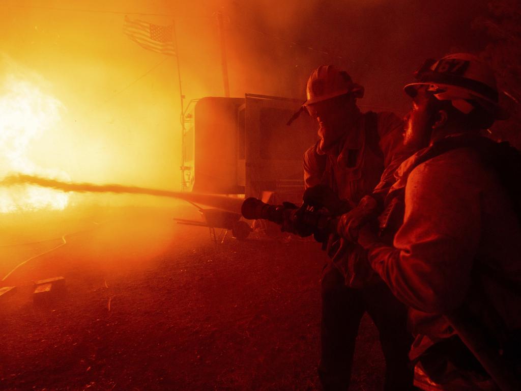 Firefighters spray water on the Hughes Fire in Castaic, California. Picture: AP