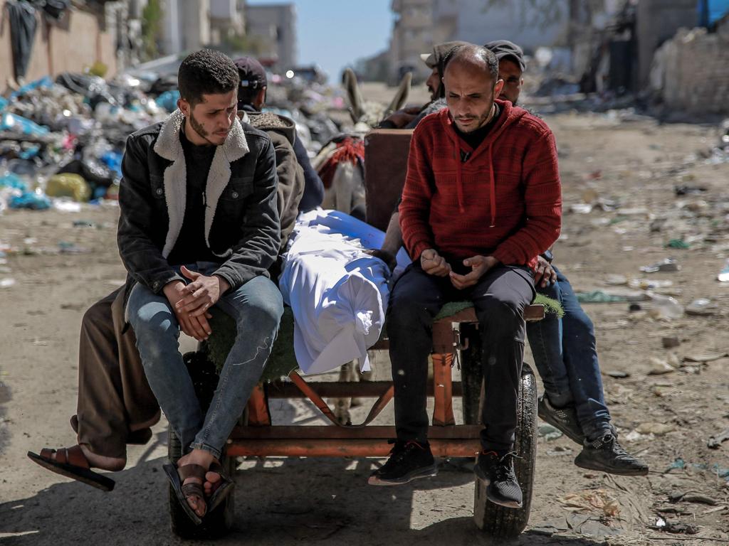 The body of a Palestinian killed in an early morning incident when residents rushed toward aid trucks in Gaza City. Picture: AFP