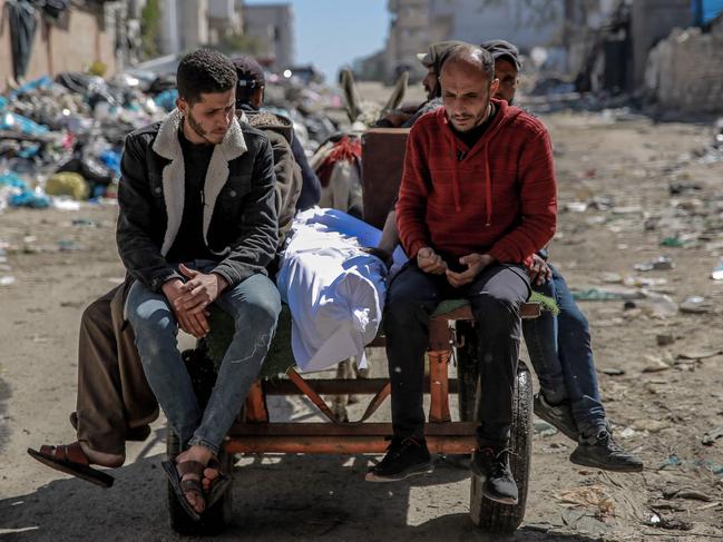 The body of a Palestinian killed in an early morning incident when residents rushed toward aid trucks in Gaza City. Picture: AFP