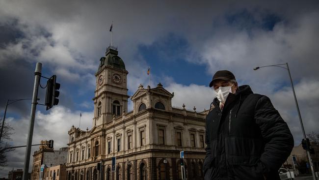 A man wearing a mask walks across Sturt Street in Ballarat on August 21, 2020 in Ballarat, Australia. Photo by Darrian Traynor/Getty Images