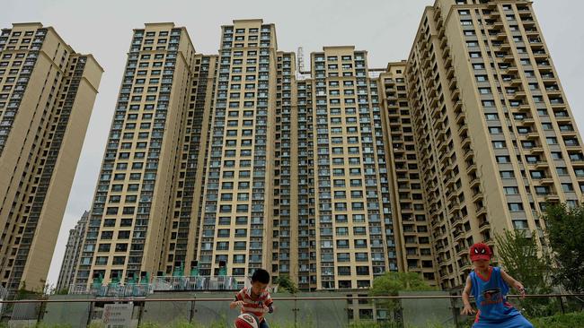 Children play basketball in front of a housing complex by ailing Chinese property developer Evergrande in Beijing. Picture: Noel Celis/SFP