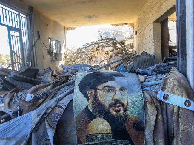 TOPSHOT - A portrait of Hezbollah chief Hassan Nasrallah sits amid destruction in a area targeted overnight by Israeli airstrikes in Saksakiyeh on September 26, 2024. Israel flatly rejected on September 26 a push led by key backer the United States for a 21-day ceasefire in Lebanon, as it vowed to keep fighting Hezbollah militants "until victory". (Photo by Mahmoud ZAYYAT / AFP)