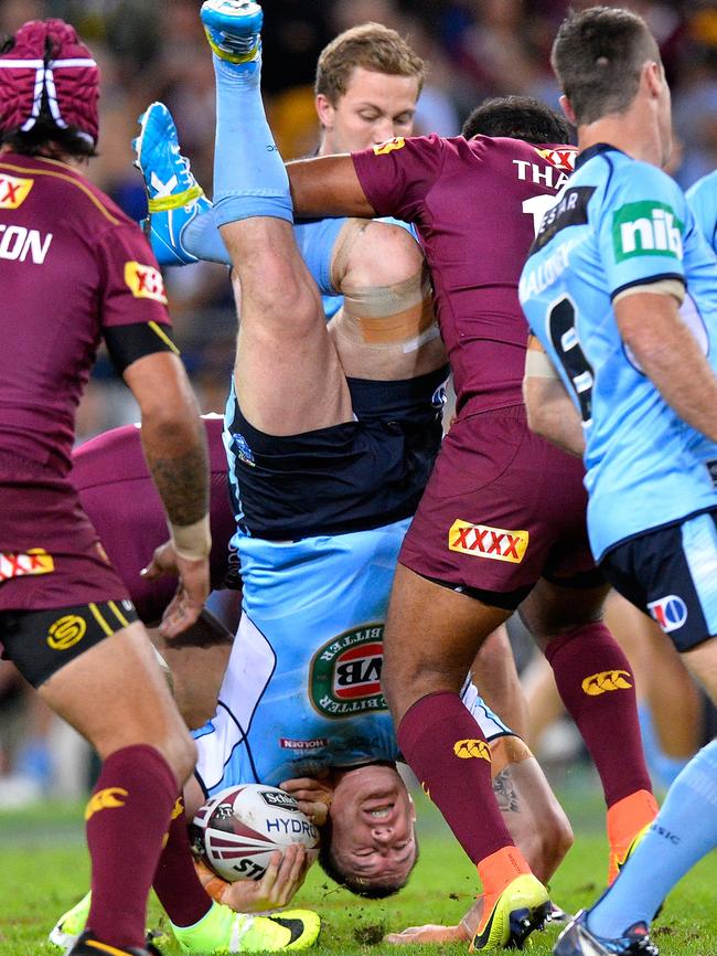 Paul Gallen is up-ended in a tackle by Sam Thaiday.