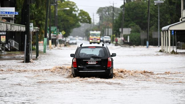 A car drives through floodwaters in Laidley. Picture: Dan Peled/Getty Images