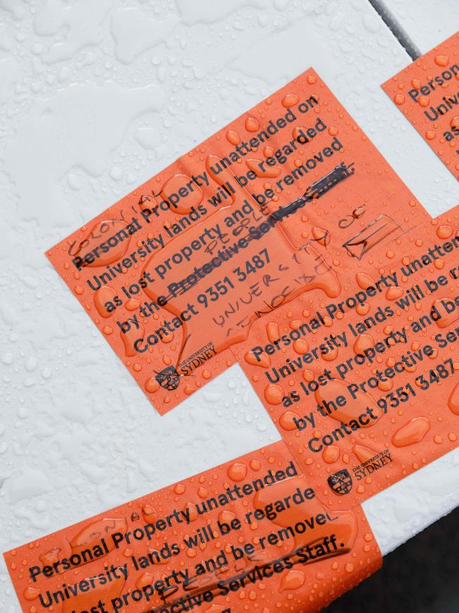 Protesters then began slapping edited versions of the stickers across the campus. Picture: NewsWire / Max Mason-Hubers
