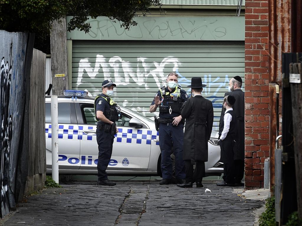 Police speak to locals near an illegal gathering at the Adass Israel Synagogue in Ripponlea. Picture: Andrew Henshaw