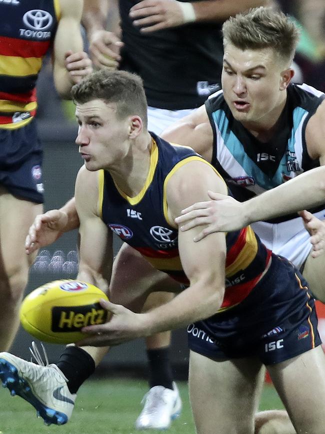 Rory Laird fires off a handball under pressure from Ollie Wines. Picture: SARAH REED