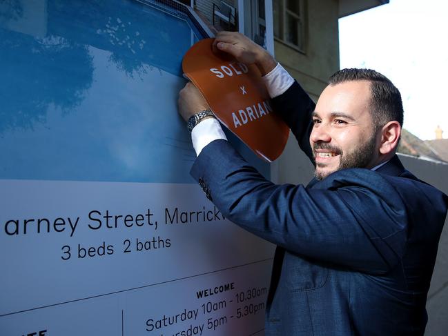 SUNDAY TELEGRAPH - Pictured is agent Adrian Tsavalas putting up the Sold sign after an Auction at 3/14 Harney St, Marrickville today. Picture: Tim Hunter.