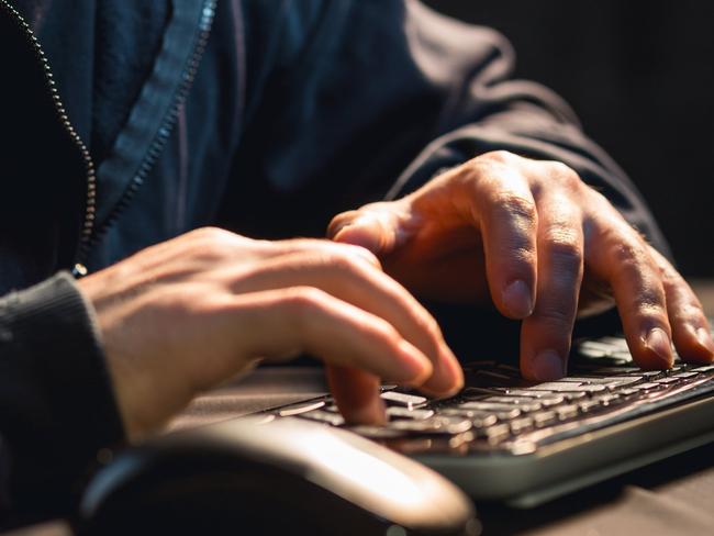 Close up of young man typing on computer keyboard