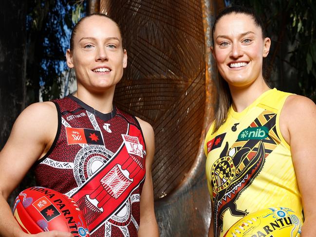 MELBOURNE, AUSTRALIA - OCTOBER 21: Stephanie Cain, Co-Captain of the Bombers and Maddie Shevlin of the Tigers pose in front of 'The Sacred Tree of our Songlines' created by Gunnai and Waradjurie man Robert Michael Young during the 2024 AFLW Indigenous Round Launch at Melbourne Museum on October 21, 2024 in Melbourne, Australia. (Photo by Michael Willson/AFL Photos via Getty Images)