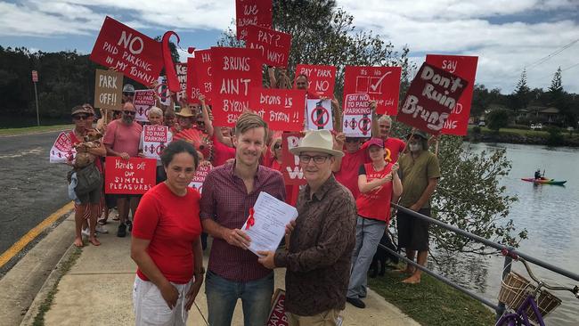 SEEING RED: Juliana Harmsen and Zac Tooth from Brunswick Heads Chamber of Commerce hand over the anti-paid parking petition containing 4,500 signatures to Byron Shire Councillor Paul Spooner, in 2017.