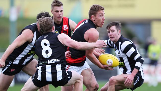 Brad Cox-Goodyer looks to hand off the ball as Magpies swarm around him. Picture: NIKKI DAVIS-JONES