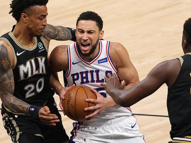 ATLANTA, GEORGIA - JUNE 18:  Ben Simmons #25 of the Philadelphia 76ers drives between John Collins #20 and Clint Capela #15 of the Atlanta Hawks during the first half of game 6 of the Eastern Conference Semifinals at State Farm Arena on June 18, 2021 in Atlanta, Georgia.  NOTE TO USER: User expressly acknowledges and agrees that, by downloading and or using this photograph, User is consenting to the terms and conditions of the Getty Images License Agreement. (Photo by Kevin C. Cox/Getty Images)