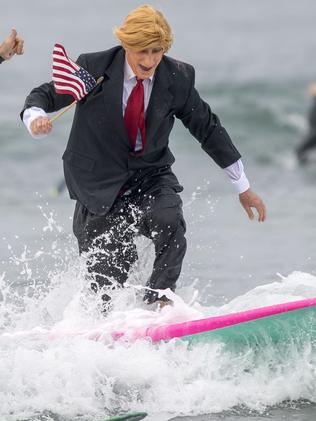 An American dressed up as former US President Donald Trump goes for a Halloween surf. Picture: AP