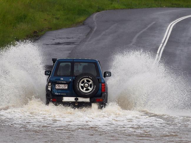 A four wheel drive braves a flooded bridge at Rocklea, west of Brisbane on January 10, 2011. Flash floods ripped through northeast Australia, killing at least one person as they swept cars and pedestrians into rapids so strong they felled trees and caused landslides. Severe downpours deluged already sodden Queensland state, with more than 300 millimetres (12 inches) falling in some places in just 24 hours, swelling rivers to fresh peaks and submerging roads and bridges.  AFP PHOTO / Patrick HAMILTON