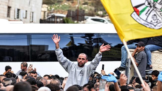 One of the Palestinian prisoners released by Israel gestures as he is surrounded by people cheering after disembarking from one of the buses of the Red Cross in Ramallah in the occupied West Bank on Saturday. Picture: Zain Jaafar / AFP