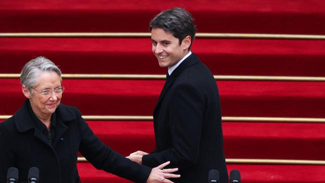 TOPSHOT – Newly appointed Prime minister Gabriel Attal (R) greets outgoing Prime minister Elisabeth Borne (L) at the end of the handover ceremony at the Hotel Matignon in Paris, on January 9, 2024. (Photo by EMMANUEL DUNAND / POOL / AFP)