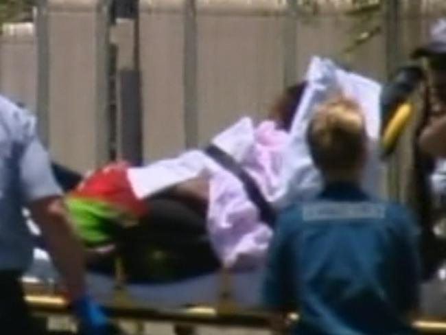 A woman believed to be Warria is taken from the scene in a stretcher with stab wounds to the chest and neck. Picture: Sky News