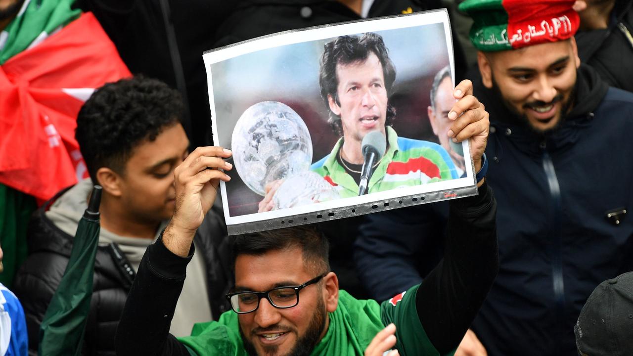 A pakistan fan holds up a picture of Pakistani Prime Minister Imran Khan
