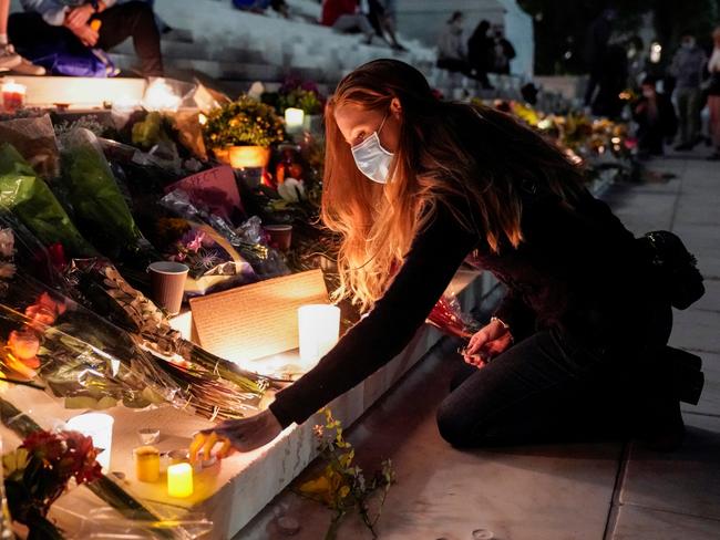 A woman lights a candle as people mourn the death of Associate Justice Ruth Bader Ginsburg at the Supreme Court in Washington, U.S., September 19, 2020.      REUTERS/Joshua Roberts