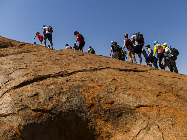 Tourists are seen climbing Uluru, also known as Ayers Rock at Uluru-Kata Tjuta National Park in the Northern Territory on the last day. Picture: AAP