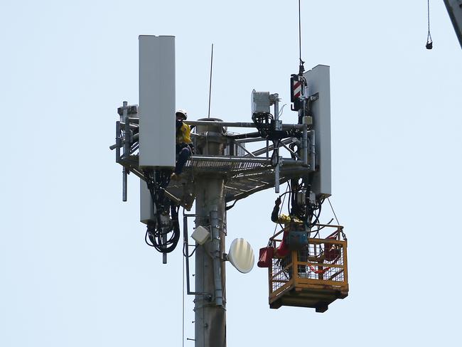 Sub-contractors completing maintenance work on a mobile phone tower used by internet companies for telecommunications service. Picture: Brendan Radke.