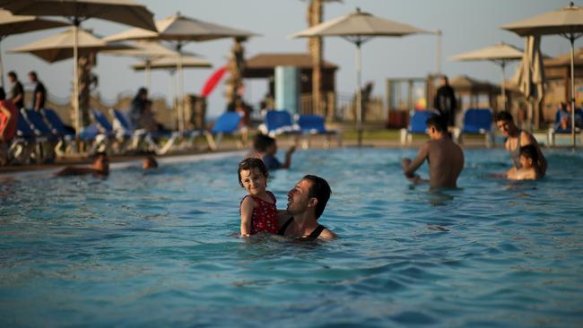 A Palestinian man with his daughter at Blue Beach Resort. Picture: Mohammed Salem / Reuters