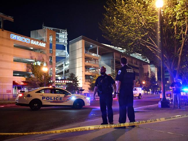 Police officers patrol a street near the Nationals Park stadium as the game between the Washington Nationals and the San Diego Padres was suspended due to a shooting.