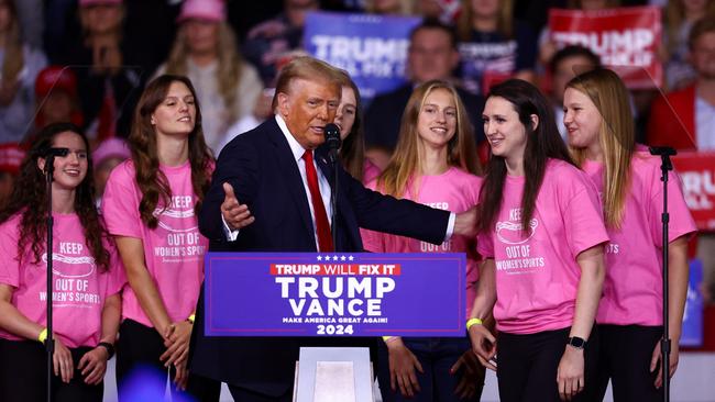 Donald Trump welcomes onstage members of the Roanoke College women’s swimming team who objected to a trans female joining the squad, at a campaign rally in Virginia on November 2. Picture: Reuters