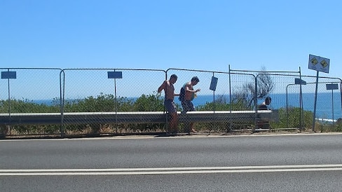 Two men push through the fence at The Pillars.