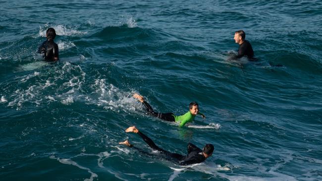 People surfing in MacKenzies Bay, in Sydney, Saturday, March 28, 2020. (AAP Image/James Gourley)