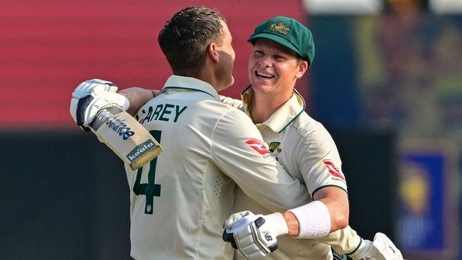 TOPSHOT - Australia's Alex Carey (L) celebrates with his captain Steve Smith after scoring a century (100 runs) during the second day of the second Test cricket match between Sri Lanka and Australia at the Galle International Cricket Stadium in Galle on February 7, 2025. (Photo by Ishara S. KODIKARA / AFP)