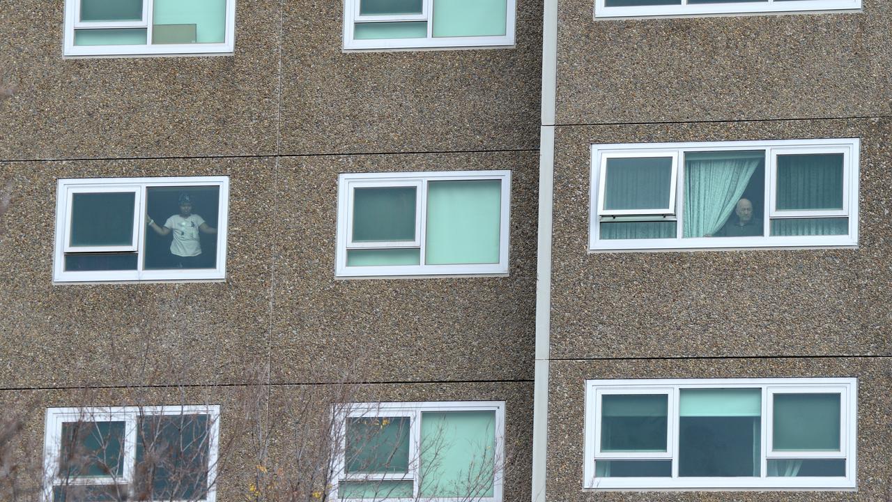 Residents look out from the North Melbourne public housing estate after it was put into lockdown on Saturday. Picture: NCA NewsWire/Andrew Henshaw