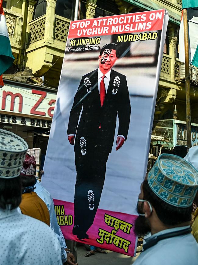 Muslims hold a placard displaying the picture of China's President Xi Jinping as they protest against the Chinese government's policies on Muslim Uighur minorities. Picture: Punit Paranjpe/AFP