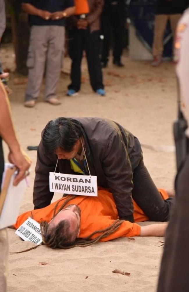 An officer appears to be on top of David Taylor during a re-enactment at Kuta Beach.